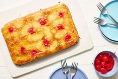 pineapple upside down cake with cherries on the top and blue plates around it