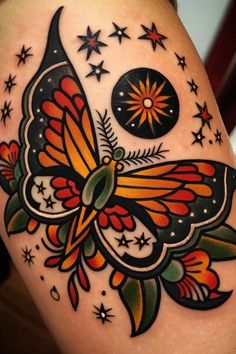 a colorful butterfly tattoo on the thigh with stars and moon in the sky behind it