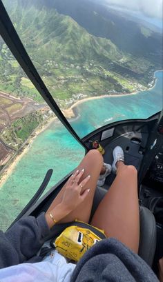 a woman is sitting in the cockpit of an airplane with her feet on the ground