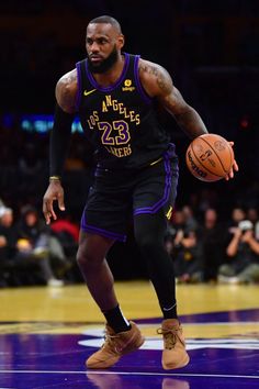 a basketball player dribbling the ball down the court with his right hand and one foot