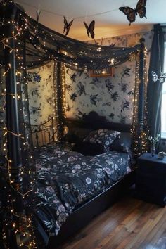 a bedroom decorated in black and white with fairy lights on the bed, butterflies flying overhead