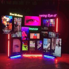 an illuminated display with multiple pictures and neon lights on the sides, in front of a dark background