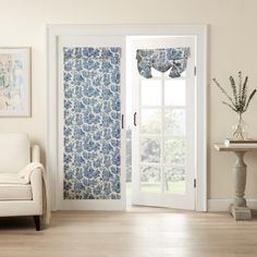 a living room with white furniture and curtains