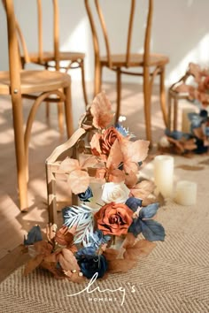 flowers and candles sit on the floor in front of chairs