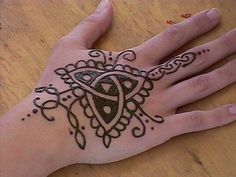 a person's hand with a henna tattoo on it and an intricate design