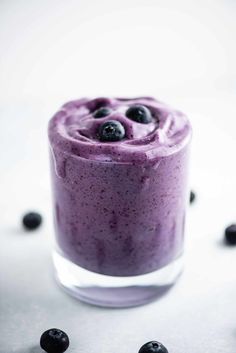 a smoothie with blueberries in it on a table