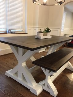 a wooden table with two benches next to it on top of a hard wood floor