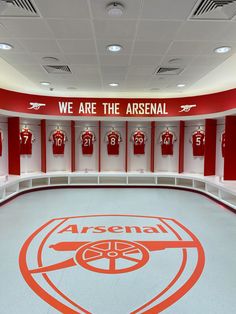 the dressing room at an asensal stadium with red and white uniforms on display