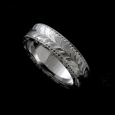 a wedding band with engraved leaves on it