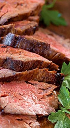 sliced steak on a cutting board with parsley