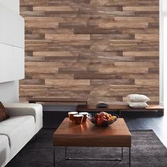 a living room filled with furniture and a wooden wall behind the coffee table on top of a rug