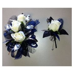 two white roses with blue ribbons on top of each other and some silver sequins