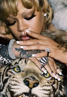 a woman with tattoos on her hands next to a tiger