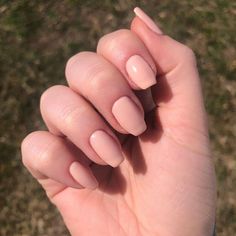 a person with long nails holding their hand up to the camera and looking down at it