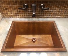 a square copper sink in a bathroom