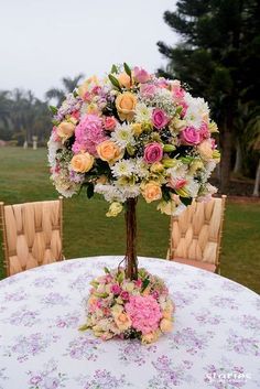 a vase filled with flowers sitting on top of a table next to two wooden chairs