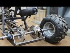 an image of a motorcycle being worked on in a shop or repair area with wheels and axles attached to the bike