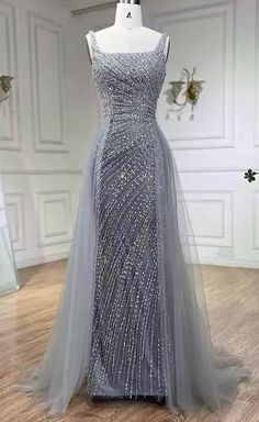 This  silver bead embellished gown with an overskirt is a show-stopping piece that exudes luxury and elegance. The gown is intricately adorned with shimmering silver beads, creating a dazzling effect that catches the light beautifully. The fitted silhouette of the gown enhances the natural curves, while the attached overskirt adds a dramatic and voluminous element, creating a sense of grandeur. This combination of the sleek, bead-embellished base and the flowing overskirt results in a balanced and captivating look, perfect for making a lasting impression at any formal event or gala. Production time is between approx 6-8 weeks. * Sizing - All items are made according to measurement ranges, they are NOT typical letter or numeric sizing. It is imperative to compare your exact measurements wit Silver Wedding Dress Older Bride, Elegant Matric Dance Dresses, Silver Gowns Elegant, Silver Dress Formal, Silver Dresses Elegant, Met Gala Gowns, Farewell Dance, Overskirt Dress, Silver Ball Gown