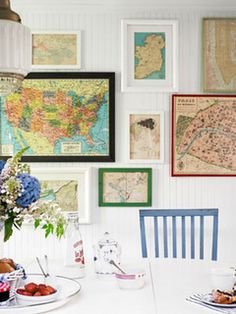 a dining room table with plates of food and pictures on the wall above it,