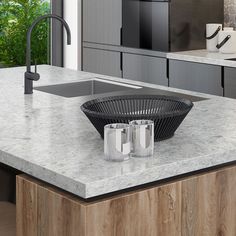 a modern kitchen with marble counter tops and stainless steel sink faucets in the center