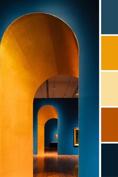 an orange and blue color scheme with wood flooring in the hallway, through which is a yellow archway