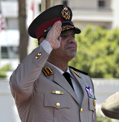 a man in uniform saluting while standing next to another man with his hand on his head