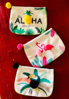 two flamingos and pineapples are on the table with aloha coin purses