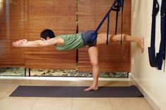 a man doing yoga on a mat in the middle of a room with bamboo blinds