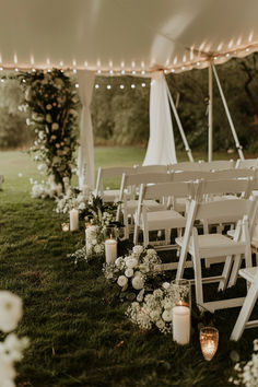 The image presents an intimate backyard wedding setup under a white tent. The setting is adorned with white folding chairs arranged in rows, an aisle lined with elegant floral arrangements, and candles in glass holders. String lights are draped along the tent's edge, adding a warm and romantic glow to the atmosphere. The overall ambiance is serene and inviting, perfect for a beautiful outdoor wedding ceremony. Microwedding Decorations, Backyard Wedding Altar, Simple Wedding Altar, Garden Wedding Themes, Wedding Inspiration Simple, Wedding Ideas Garden, Outside Wedding Ceremonies, Love In Full Bloom, Backyard Wedding Ideas