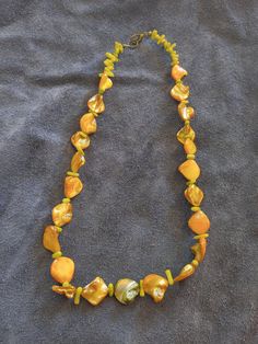 This necklace features golden colored Abalone shell beads and seafoam color dyed coral beads. This is a great addition to anyone who enjoys the beach life. Elegant Yellow Beach Jewelry, Elegant Yellow Jewelry For The Beach, Adjustable Single Strand Jewelry For Vacation, Unique Gold Jewelry For Vacation, Adjustable Multicolor Pearl Necklace For Beach, Orange Spiritual Jewelry For Beach, Yellow Necklaces For Beach, Yellow Necklaces For Beach Occasion, Adjustable Single Strand Necklace For Vacation