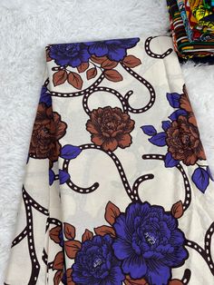 the fabric has blue flowers on it and is laying on a white furnishing