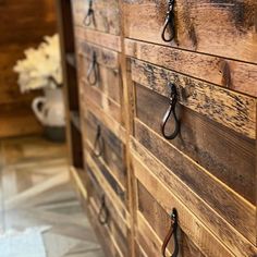 an old wooden dresser with black handles and some scissors hanging on the handlebars