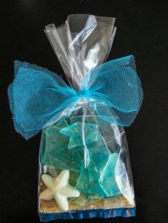 a bag filled with starfish on top of a black table next to a blue ribbon