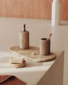 a soap dispenser sitting on top of a counter next to a cup