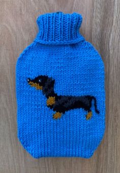 a knitted hot water bottle cover with a dachshund design on it