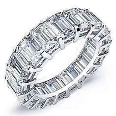 an emerald - cut diamond ring set with three rows of baguetts in white gold