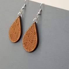 Wood earrings in a teardrop shape engraved with a fun pattern handcrafted from wood in the USA in a small father and daughter wood shop in Northern California.Nickel Free Wire HooksWood is sealed - lightly coated with a a clear finish.1.5" x 1" x .13" thickThis is not the exact pair of dangle hook earrings that will be shipped. Wood grain and coloring will vary with each piece. Our redwood earrings and necklaces are made out of salvaged California Redwood. No trees were harvested or cut to produce this necklace or any of our redwood jewelry. California Souvenirs, Coaster Crafts, Wood Keychain, Father And Daughter, Wood Ornaments, Wood Earrings, Hat Pins, Wood Jewellery, Handmade Wood