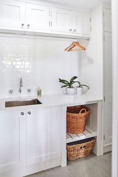 a kitchen with white cabinets and a basket in the corner next to the sink on the counter