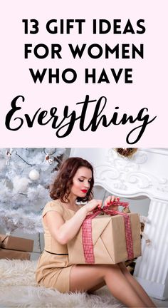 a woman sitting in front of a christmas tree holding a present box with the words 13 gift