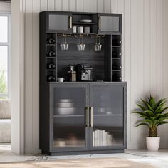 a large black cabinet with glass doors and shelves on the side, in front of a white wall