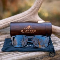 an antler kings sunglasses and case sitting on top of a wooden table