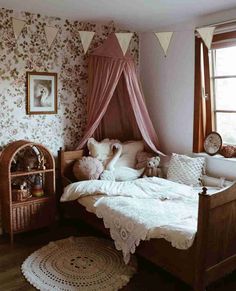 a room with a bed, rugs and pictures on the wall above it is decorated in pink