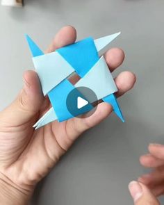 someone is holding an origami bird in their left hand and pointing it at the camera