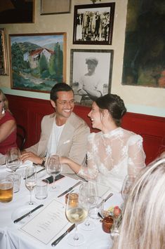 two people sitting at a table with wine glasses