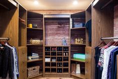 a walk in closet filled with lots of wooden shelves