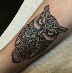 an owl tattoo on the arm