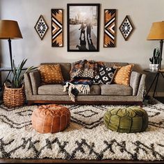 a living room filled with lots of furniture next to two lamps and pictures on the wall