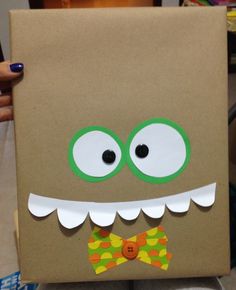 a brown box with green eyes and a bow tie on it's head is decorated to look like a monster