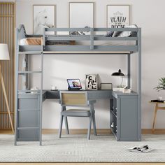 a loft bed with desk underneath it in a living room next to a wall mounted poster