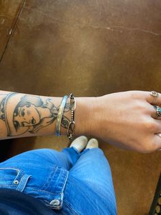 a person's arm with tattoos on it, and two rings around their wrist